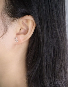 Detail of silver S925 cupid bow earring with zircon stone on model's ear