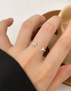 Macro detail of S925 sterling silver starfish ring with textured glitter finish on fingers