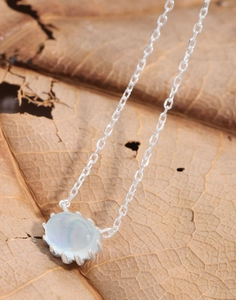 Detailed view of an oval aquamarine pendant on a S925 sterling silver chain with a leaf