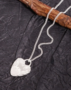 Detailed macro view of S925 silver heart pendant necklace with floral engravings