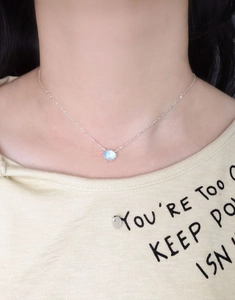 Macro view of S925 sterling silver necklace with oval light blue gemstone pendant