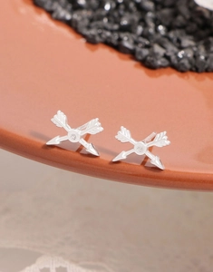 Close-up of S925 sterling silver crossed arrow studs with a sparkling zircon center