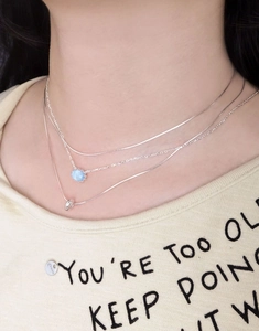 Detailed view of triple-layered 925 silver necklace with oval aquamarine stone and ring