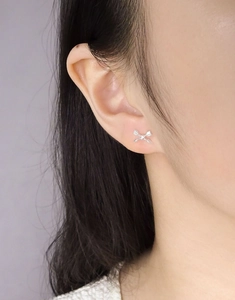Close-up of S925 silver cupid heart arrow stud earring worn on a model's ear