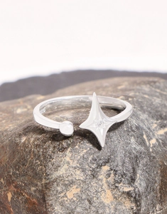 Macro shot of S925 sterling silver star ring with zircon on dark rock surface