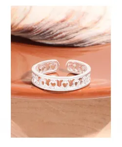 Detail shot of the adjustable S925 sterling silver ring featuring hollow heart patterns