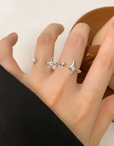 Detailed close-up of a silver starburst adjustable ring with zircon on a model finger