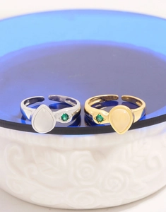 Detail of adjustable S925 silver pear-shaped agate ring with green zircon star accent