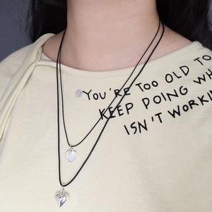 Double-layer black cord adjustable necklace featuring two silver heart pendants on model