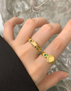 Detail of two vintage gold S925 silver rings with pear-shaped agate and colorful gemstones