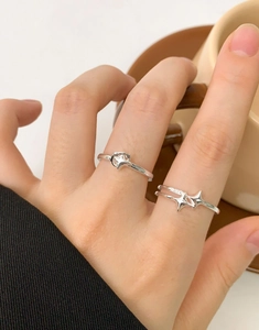 Détail de deux bagues étoiles en argent 925 avec zircons sur une main de femme