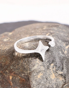 Macro detail of S925 sterling silver star ring with zircon stone on dark rock texture