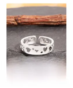 Macro detail of S925 sterling silver ring showing hollow heart and circle cutout patterns