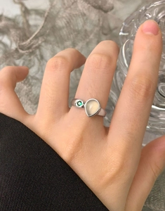 Detail of pear-shaped white agate and green stone on an adjustable S925 silver ring