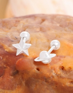 Macro detail of S925 sterling silver star and planet stud earrings on stone