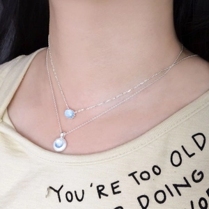 Double-layered S925 silver necklace with oval sky blue aquamarine pendants on a model