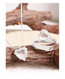 Close-up of S925 silver heart necklace and ring set with iridescent moonstone