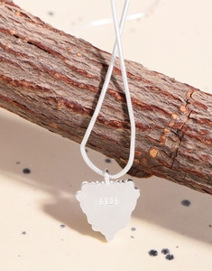 Macro view of S925 sterling silver heart pendant featuring the metal hallmark and snake chain