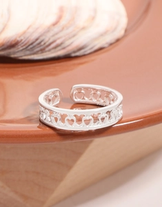Detailed view of S925 sterling silver ring featuring hollow heart patterns and open band