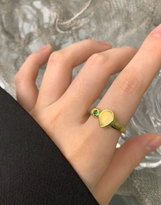 Close-up of S925 silver pear-shaped yellow agate ring worn on finger with green stone
