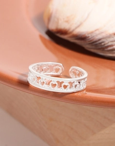 Detailed view of the hollow heart-shaped S925 sterling silver open ring on a ceramic tray