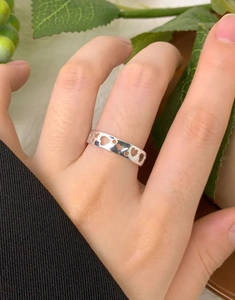Close-up of S925 sterling silver ring with hollow heart design worn on a hand