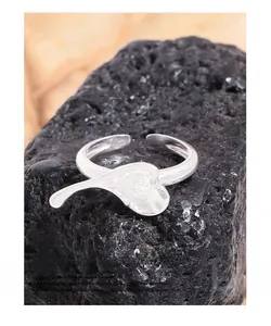 Detailed macro shot of irregular S925 sterling silver heart ring on a black rock surface