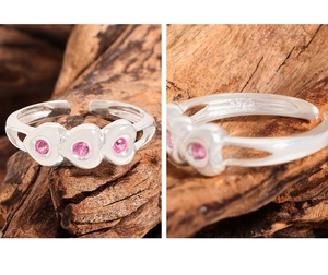 Detail shot of the S925 sterling silver hallmark and three pink heart-shaped gemstones