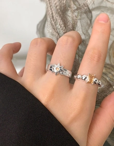 Detail of S925 sterling silver rings with yellow gemstones and sunburst pattern on hand
