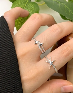Détail de bagues étoile de mer en argent S925 avec diamants brillants portées par femme