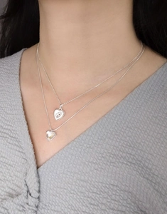 Detail of layered heart necklace featuring opal stone and sterling silver snake chain