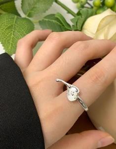 Irregular liquid S925 sterling silver heart ring worn on finger with floral background