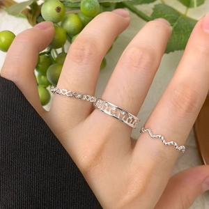 Three-piece S925 sterling silver heart ring set shown on fingers with a green berry background