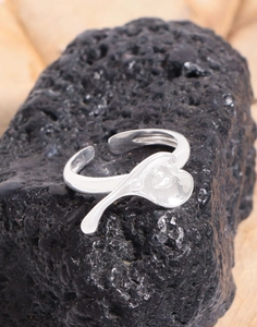 Detailed close-up of an irregular silver heart ring with a polished adjustable band
