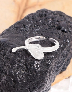Detailed shot of S925 sterling silver heart ring on black volcanic stone textured background