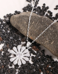 Macro view of S925 sterling silver daisy pendant necklace with sparkling zircon pavé