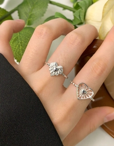 Detailed view of S925 sterling silver heart rings with intricate feather relief on finger
