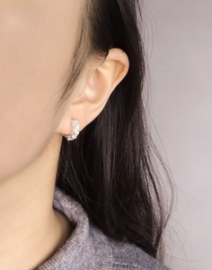 Close-up of small S925 sterling silver hoop earrings with pavé zircon stones on ear