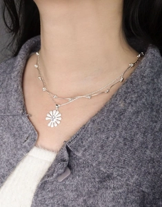 Close-up of double-layer S925 silver daisy pendant necklace on model collarbone