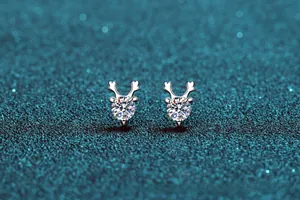 Macro view of S925 silver reindeer antler stud earrings featuring sparkling round moissanite