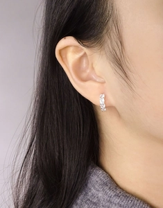 Close-up of S925 sterling silver hoop earring with cubic zirconia on a female model