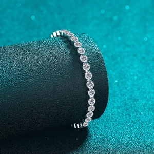 Sparkling S925 sterling silver tennis bracelet with round cut moissanite on a teal pedestal
