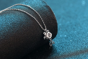 Macro d'un collier pendentif carpe koi en argent S925 avec moissanite sur support noir poli