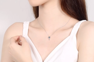 Gros plan d'un collier en argent S925 avec pendentif goutte bleue sur le cou d'un mannequin