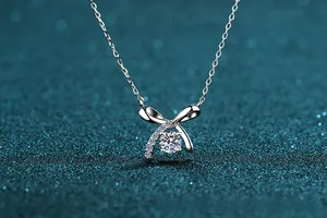 Close-up of S925 silver bow necklace with a sparkling round moissanite pendant