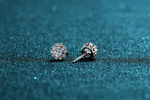 Macro shot of S925 sterling silver four-prong halo stud earrings with brilliant moissanite