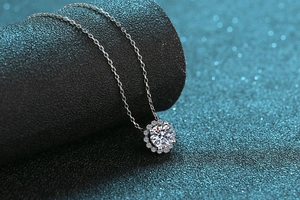 Gros plan du pendentif moissanite en argent S925 avec serti halo sur support noir