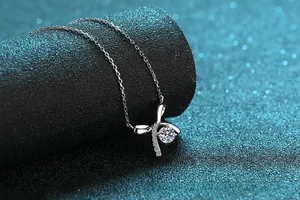 Close-up of S925 silver necklace with sparkling bow pendant and center moissanite stone