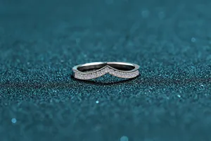 Macro shot of V-shaped S925 silver ring with moissanite pavé on glittery background