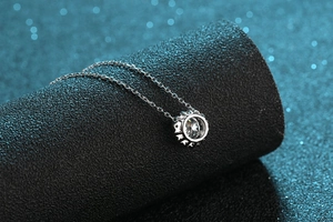 Gros plan du collier en argent S925 avec pendentif moissanite sur un support noir